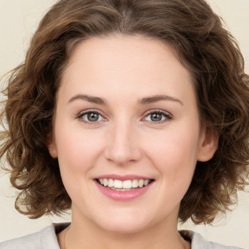 Joyful white young-adult female with medium  brown hair and green eyes