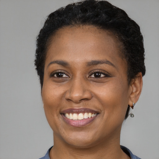 Joyful black young-adult female with short  brown hair and brown eyes