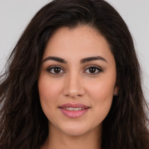 Joyful white young-adult female with long  brown hair and brown eyes