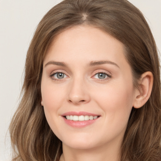 Joyful white young-adult female with long  brown hair and grey eyes