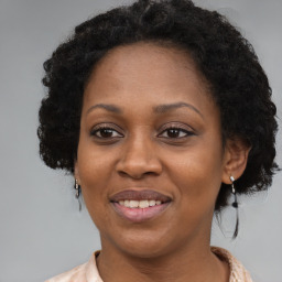 Joyful black adult female with medium  brown hair and brown eyes