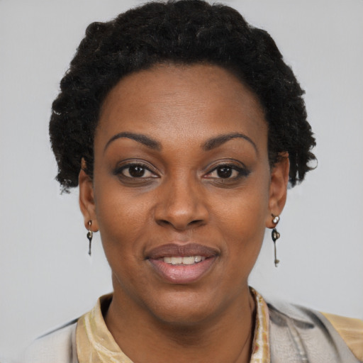 Joyful black adult female with short  black hair and brown eyes