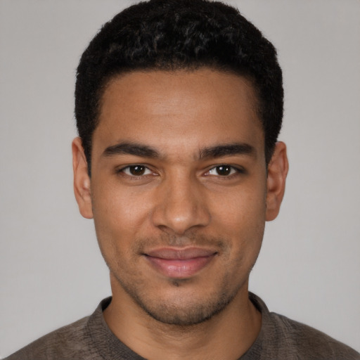 Joyful black young-adult male with short  black hair and brown eyes