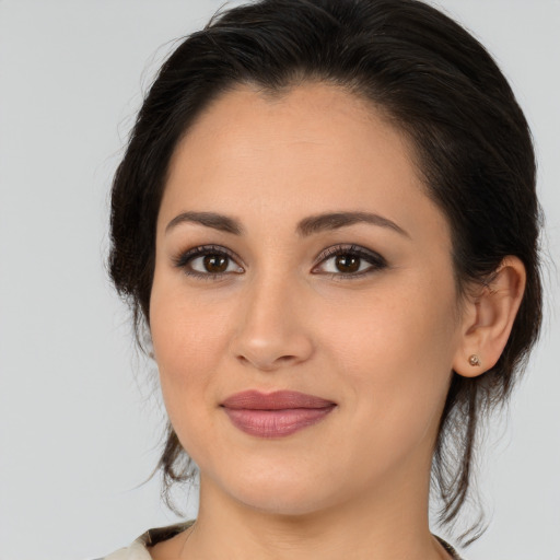 Joyful latino young-adult female with medium  brown hair and brown eyes