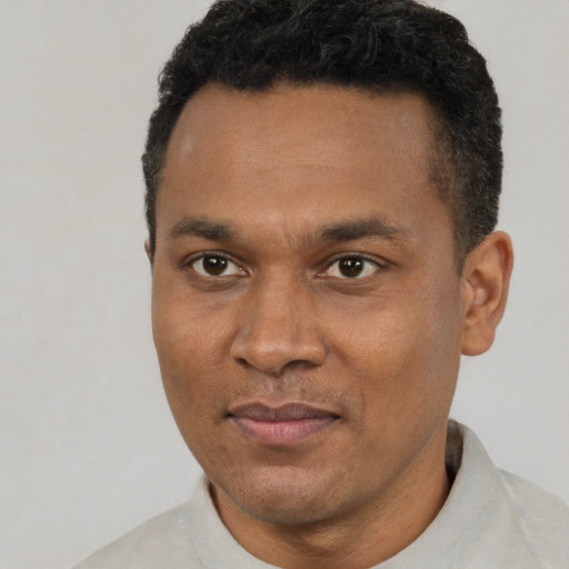 Joyful black young-adult male with short  brown hair and brown eyes