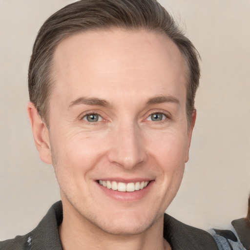 Joyful white adult male with short  brown hair and grey eyes