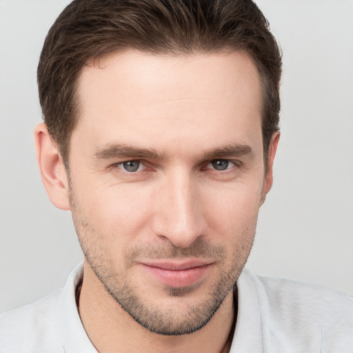 Joyful white young-adult male with short  brown hair and grey eyes