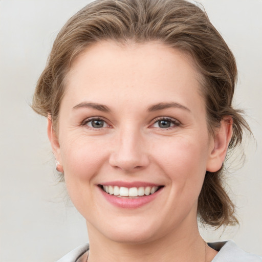 Joyful white young-adult female with medium  brown hair and grey eyes