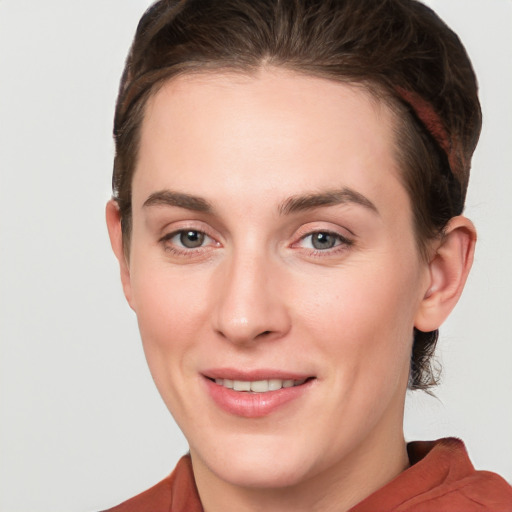 Joyful white young-adult female with short  brown hair and grey eyes