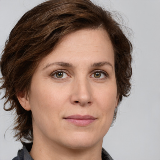 Joyful white young-adult female with medium  brown hair and green eyes