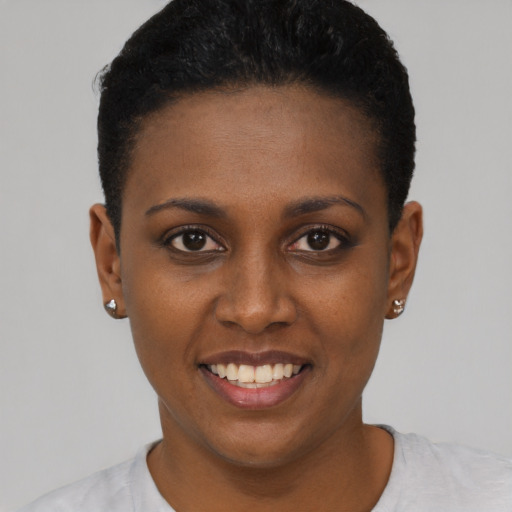 Joyful black young-adult female with short  black hair and brown eyes