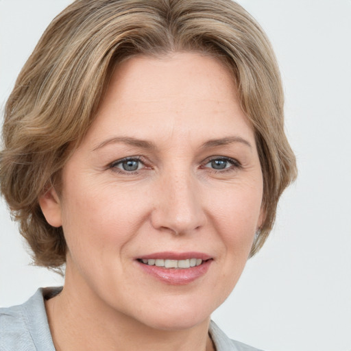 Joyful white adult female with medium  brown hair and grey eyes