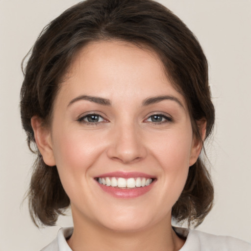 Joyful white young-adult female with medium  brown hair and brown eyes