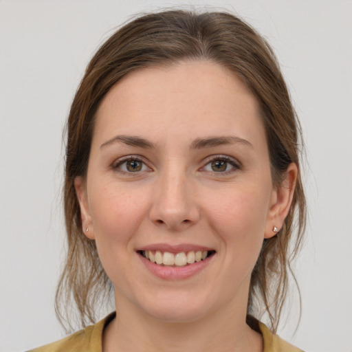 Joyful white young-adult female with medium  brown hair and grey eyes