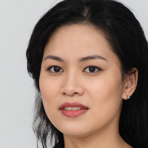 Joyful asian young-adult female with long  black hair and brown eyes