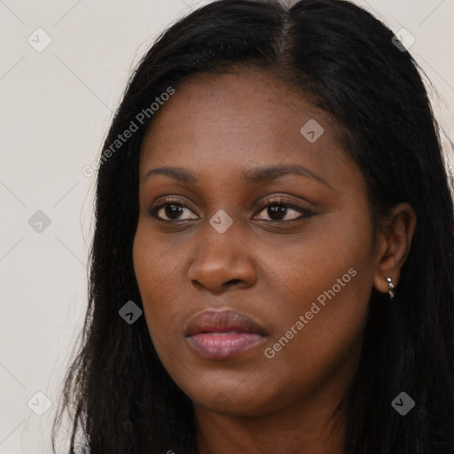 Joyful black young-adult female with long  black hair and brown eyes