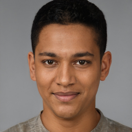 Joyful black young-adult male with short  black hair and brown eyes