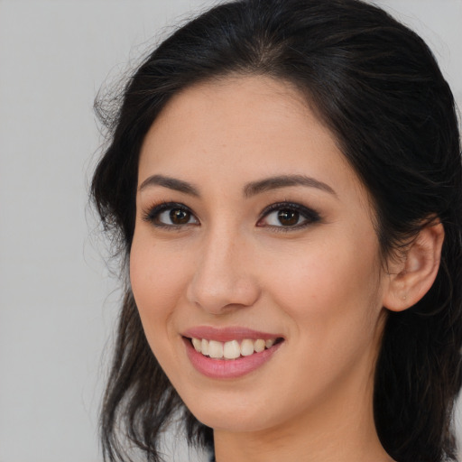 Joyful latino young-adult female with long  brown hair and brown eyes