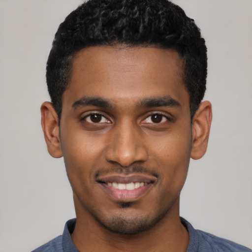 Joyful black young-adult male with short  black hair and brown eyes