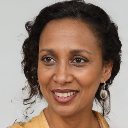 Joyful black adult female with medium  brown hair and brown eyes