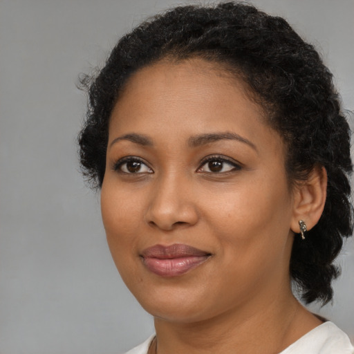 Joyful black young-adult female with medium  black hair and brown eyes
