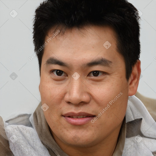 Joyful asian young-adult male with short  brown hair and brown eyes