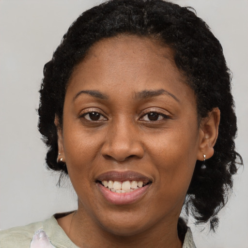 Joyful black adult female with short  brown hair and brown eyes