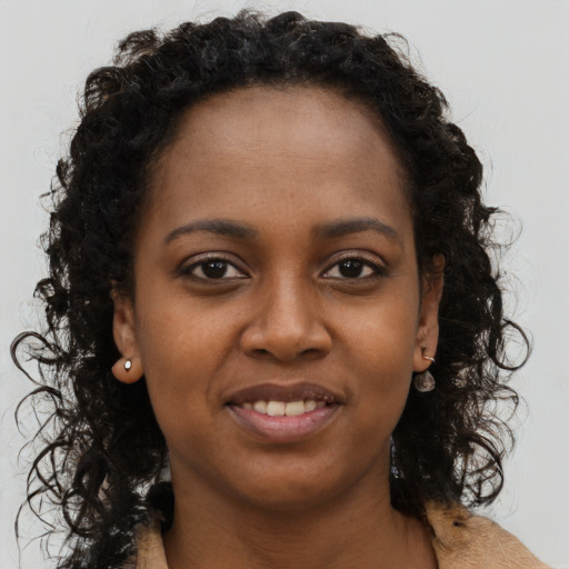Joyful black young-adult female with long  brown hair and brown eyes