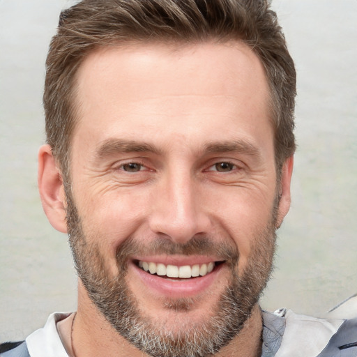 Joyful white adult male with short  brown hair and brown eyes