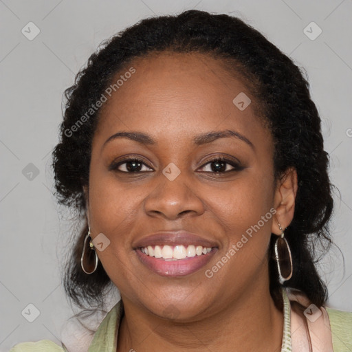 Joyful black young-adult female with long  brown hair and brown eyes