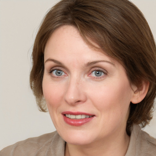 Joyful white adult female with medium  brown hair and blue eyes