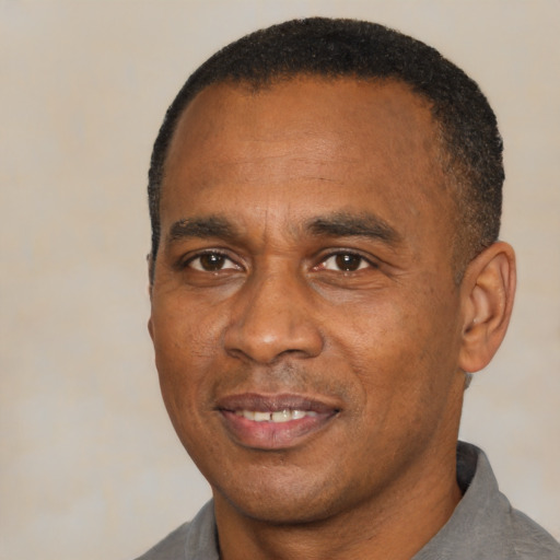 Joyful black adult male with short  black hair and brown eyes