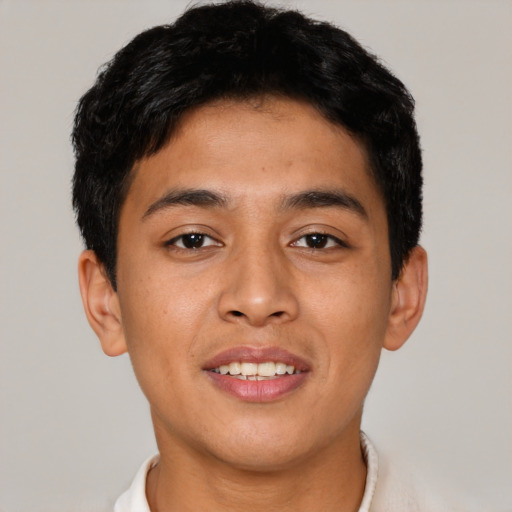 Joyful latino young-adult male with short  brown hair and brown eyes