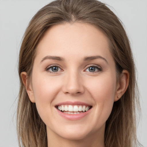 Joyful white young-adult female with long  brown hair and grey eyes