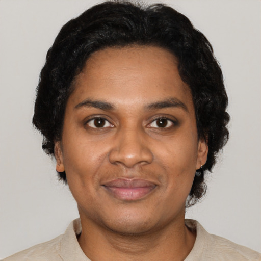 Joyful black adult female with short  black hair and brown eyes