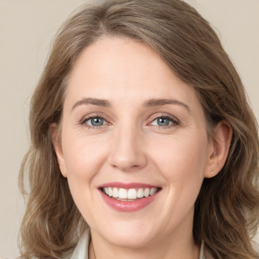 Joyful white young-adult female with long  brown hair and green eyes