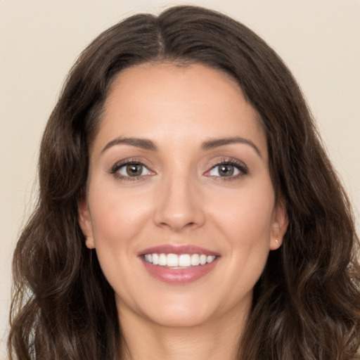 Joyful white young-adult female with long  brown hair and brown eyes