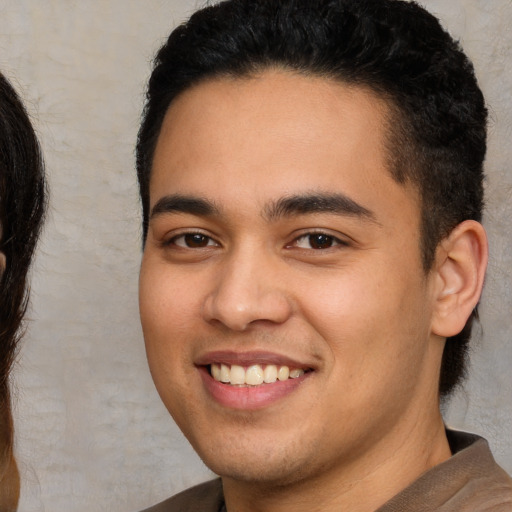 Joyful white young-adult male with short  black hair and brown eyes