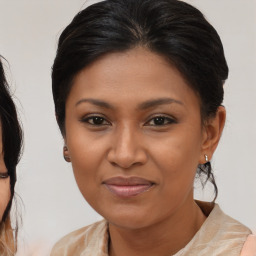 Joyful black adult female with medium  brown hair and brown eyes