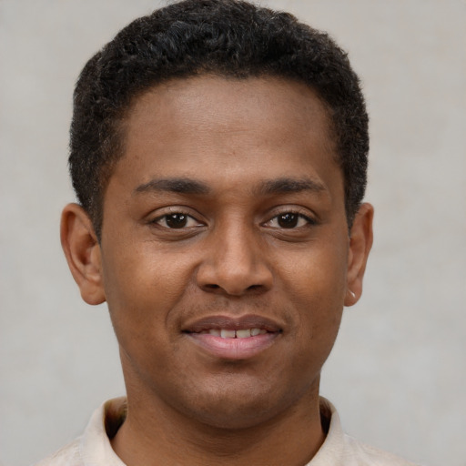 Joyful latino young-adult male with short  brown hair and brown eyes