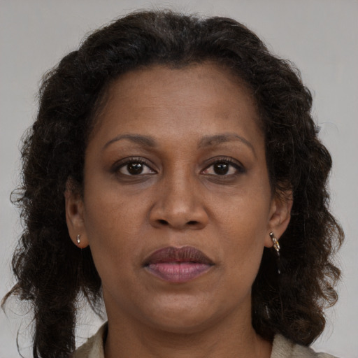 Joyful black adult female with long  brown hair and brown eyes