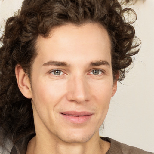 Joyful white young-adult male with medium  brown hair and green eyes