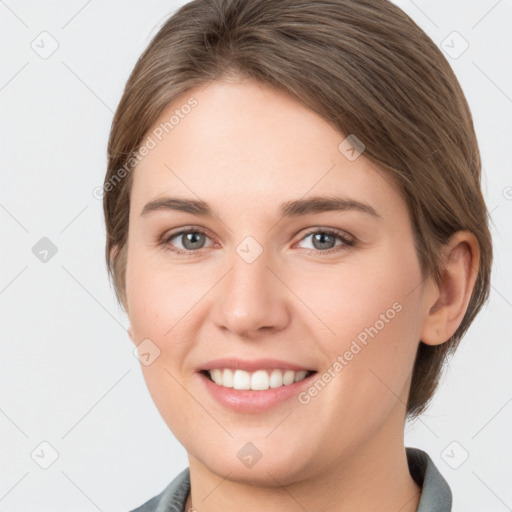 Joyful white young-adult female with medium  brown hair and grey eyes