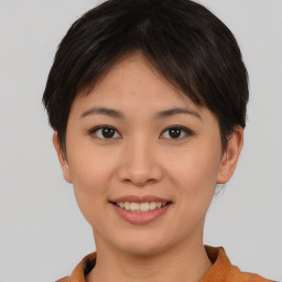 Joyful asian young-adult female with short  brown hair and brown eyes