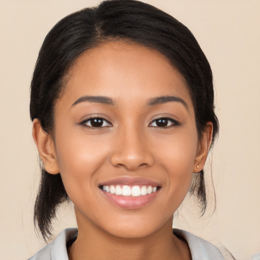 Joyful latino young-adult female with long  black hair and brown eyes