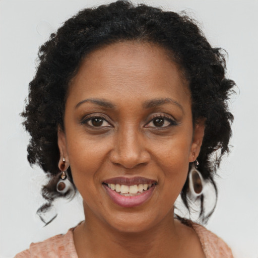 Joyful black adult female with medium  brown hair and brown eyes