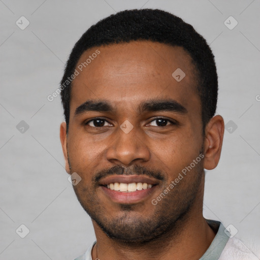 Joyful black young-adult male with short  black hair and brown eyes