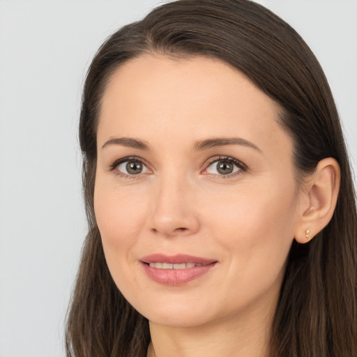 Joyful white young-adult female with long  brown hair and brown eyes