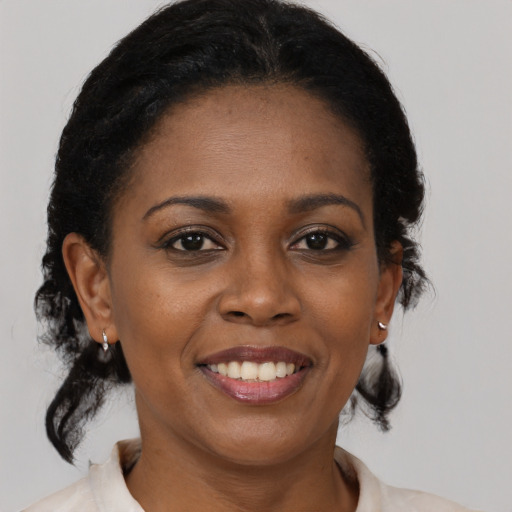 Joyful black young-adult female with medium  black hair and brown eyes