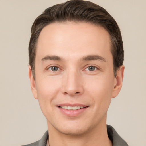 Joyful white young-adult male with short  brown hair and grey eyes